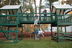 three children are playing on a green play set