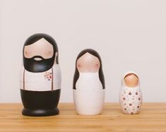 three nesting dolls sitting on top of a wooden table