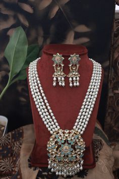 Turquoise Gold Plated Meenakari and Pearl Necklace. This regal Necklace Set is based on material of copper alloy. The four pearl strands end into a beautiful work of meenakari in an intricate floral pattern. the floral pattern is embellished with kundan and pearls ending into a waterfall of pearls. The piece is plated with 22k gold. This beauty is a must in your traditional jewelry collection. LENGTH Necklace Size - 26 inches. Closure - Adjustable Dori. Earring Size- 6 cm DETAILS -100% top Quali Turquoise Kundan Necklace With Meenakari Detailing, Blue Meenakari Chandbali Necklace, Traditional Turquoise Necklace With Meenakari, Traditional Turquoise Meenakari Necklace, Turquoise Chandbali Jewelry For Festivals, Traditional Kundan Necklace In Turquoise, Turquoise Kundan Temple Jewelry, Turquoise Meenakari Jewelry For Gifts, Turquoise Meenakari Necklace For Wedding