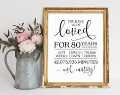 a sign that says you have been loved for 50 years and flowers in a vase