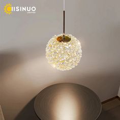 a round table with a lamp hanging from it's center and the light on top