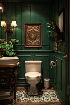 a toilet and sink in a small room with green paint on the walls, wood paneling