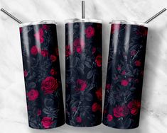 three black and red floral tumblers on a white marble surface with two straws