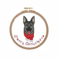 a cross stitch pattern with a german shepard dog wearing a red scarf and the words merry christmas