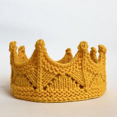 a knitted yellow crown sitting on top of a white table