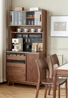 a dining room table and chairs in front of a wooden cabinet with coffee maker on it