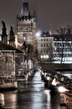 an image of a city at night with lights on the buildings and water in the foreground