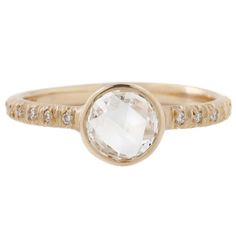 a gold ring with an oval white diamond