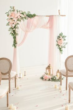 the wedding arch is decorated with white flowers and greenery