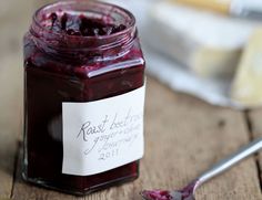 a jar of raspberry jam with a spoon next to it