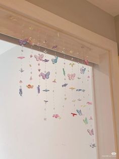 a window with butterflies hanging from it's side