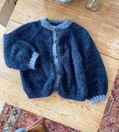 a blue sweater sitting on top of a wooden table