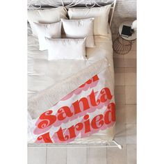 an overhead view of a bed with white sheets and red lettering on the comforter