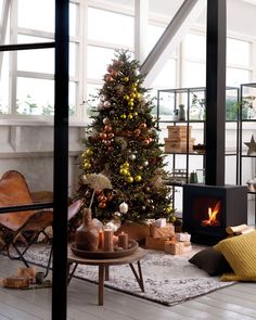 a living room with a christmas tree in the corner and other decorations on the floor