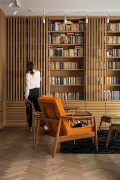 a woman standing in front of a bookshelf filled with shelves full of books