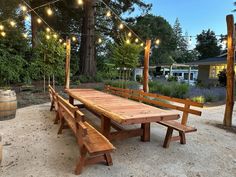 a wooden picnic table with lights strung over it