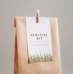 a brown paper bag with a label on it that says survival kit and trees in the background