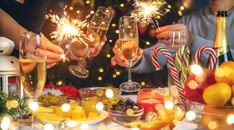 two people toasting with sparklers in front of christmas decorations and candy canes