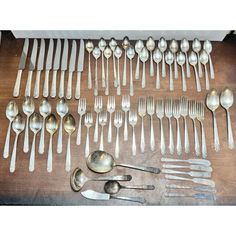 an assortment of spoons and forks on a table