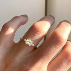 a woman's hand with a diamond ring on it