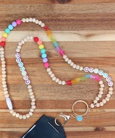 a wooden beaded lanyard with a cell phone and keychain on it