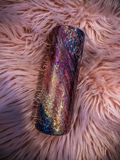 a purple and blue vase sitting on top of a pink fur covered floor with lots of glitter