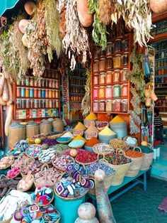 an outdoor market with lots of colorful items on display and hanging from the ceiling above