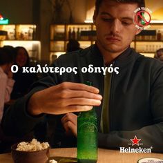 a man sitting at a table with a beer bottle in front of him and popcorn