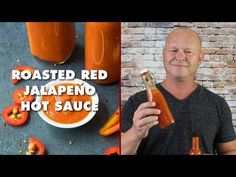 a man holding a bottle of jalapeno hot sauce