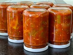 six jars filled with food sitting on top of a table