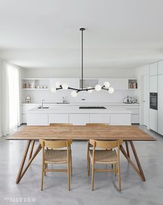 a large wooden table sitting in the middle of a kitchen