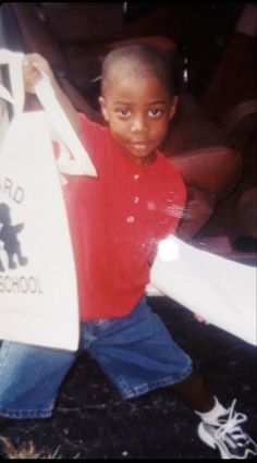 a young boy is holding up a sign