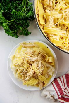 pasta with chicken and parmesan cheese in a bowl next to broccoli