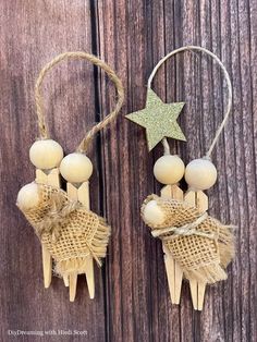 two small wooden pegs are attached to string and hang on a wood background with a star