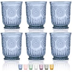 six glass cups with different colors and designs on the bottom, all lined up in rows