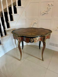 an ornately decorated coffee table in the middle of a room with stairs and handrails