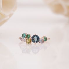 Multi Stone Cluster ring, Cluster engagement ring, Teal Sapphire ring, Moonstone, Peridot, Emerald, Moissanite cluster ring, Gift For Her Main Stone: Teal Sapphire  Main Stone Color: Teal Main Stone Shape: Round Secondary Stone: Simulated Diamond & Sapphire Secondary Stone Color: White, Green & Blue Secondary Stone Shape: Round Jewelry Type: Designer Ring Metal: 925 Sterling Silver Method: Handmade Personalization: Possible Occasion: Engagement Style: Art Deco Ring Size: We make rings from US 3 Elegant Silver Multi-stone Cluster Ring, Platinum Multi-stone Cluster Ring, Classic Blue Multi-stone Cluster Ring, Sapphire Multi-stone Cluster Ring Gift, Elegant Blue Multi-stone Cluster Ring, Engagement Style, Cluster Engagement Ring, Big Rings, Art Deco Ring