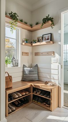 a wooden bench sitting under a window next to a pair of shoes on top of a shelf