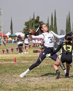 two girls are playing football on the field