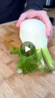 a person is cutting up some vegetables on a wooden board