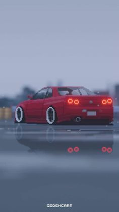 a red car driving down a street next to a tall white building in the background