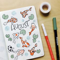 an open notebook with the words august written on it next to some markers and pencils