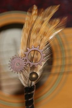 a close up of a metal object with feathers on it