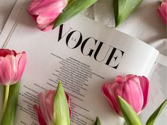 pink tulips on top of an open book with the word voge written in it