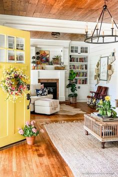 a living room filled with furniture and a fire place next to a doorway that leads into a kitchen