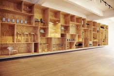 an empty room with wooden shelves filled with lamps and other items on the shelfs