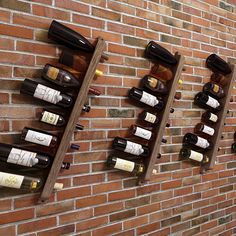 several wine bottles are lined up against a brick wall with wooden racks holding them on it