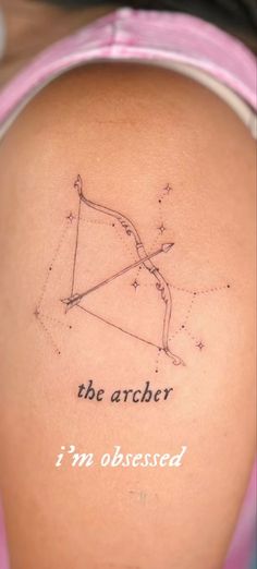 the back of a woman's shoulder with an arrow tattoo on it