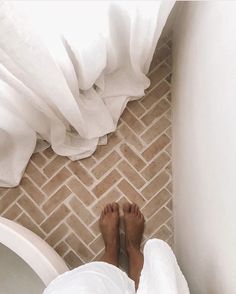 a person's feet are standing on the bathroom floor