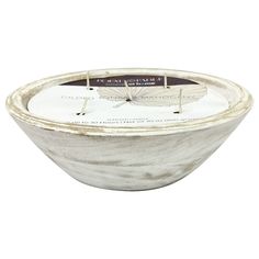 a white bowl filled with candles on top of a table